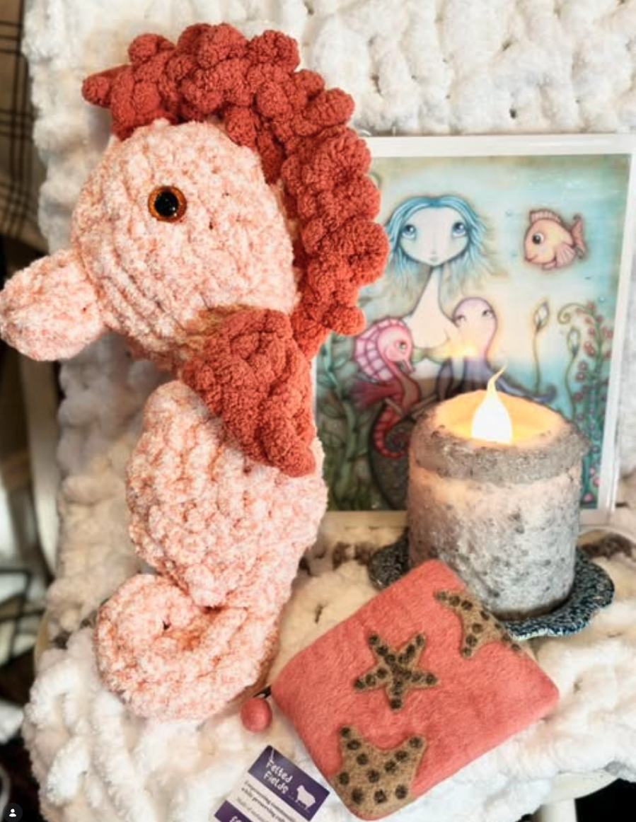 Handmade coastal gift display with a plush seahorse and candle
